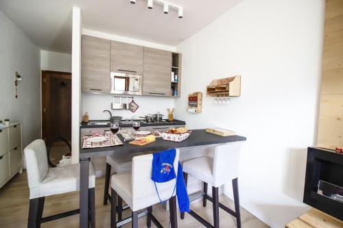 a kitchen with a table and chairs in a room at Casa Franz in Val di Fassa by Zoom In Earth in Mazzin