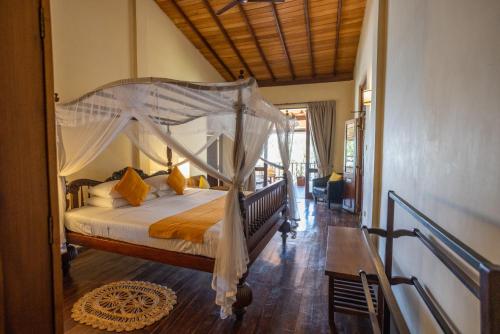 a bedroom with a bed with a canopy at South Point Abbey in Ahangama