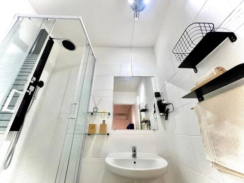 uma casa de banho com um lavatório e uma cabina de duche em vidro. em T1 - Le paille en queue - neuf, vue jardin, 11min aéroport em Saint-Denis