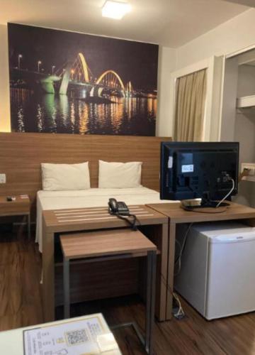 um quarto com uma cama e uma secretária com um computador em S4 HOTEL Aguas Claras TorresReis em Brasília