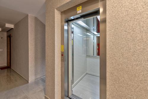 una puerta de cristal a una ducha a ras de suelo en un edificio en Apartman Milosavljević, en Zlatibor