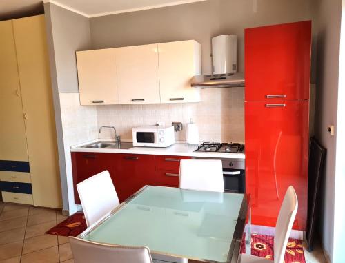 een keuken met een glazen tafel en een rode koelkast bij Betulle 2G in Leinì