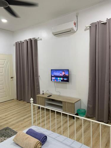 a living room with a tv on the wall at Lala Homestay 1 in Kuala Terengganu