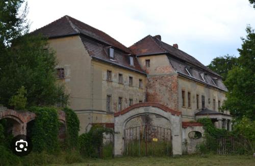 an old building with a gate in front of it at Mieszkanie na wsi in Trzebiel