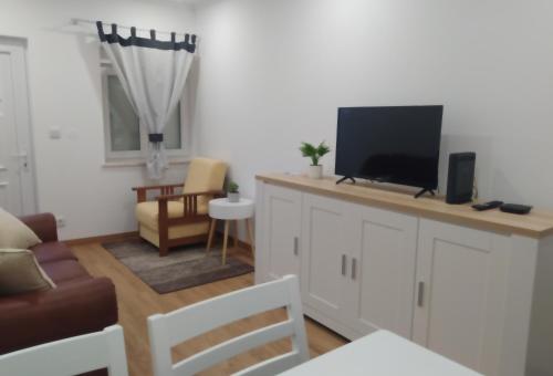 a living room with a flat screen tv on a counter at Mondalva Apartamentos in São Pedro de Alva