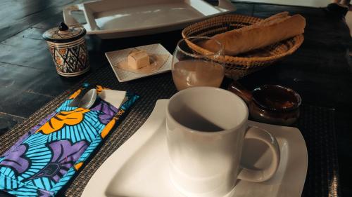 a table with a cup of coffee and a napkin at AKINE TI KASSO piscine in Diembéreng