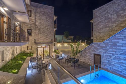 a patio with chairs and a swimming pool at night at Aelia Sivota in Syvota