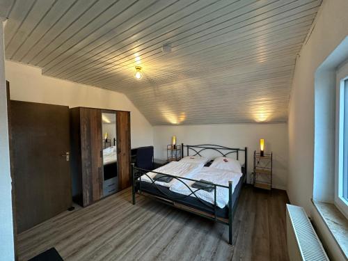 een slaapkamer met een bed en een houten plafond bij Ruhige Ferienwohnung bei Bamberg in Stegaurach