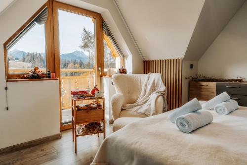 um quarto com uma cama, uma cadeira e uma janela em Mountain Base - Dom Hrabiego em Zakopane