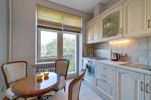 una cocina con una mesa con dos vasos de zumo de naranja. en Arena Park Apartment, en Kaunas