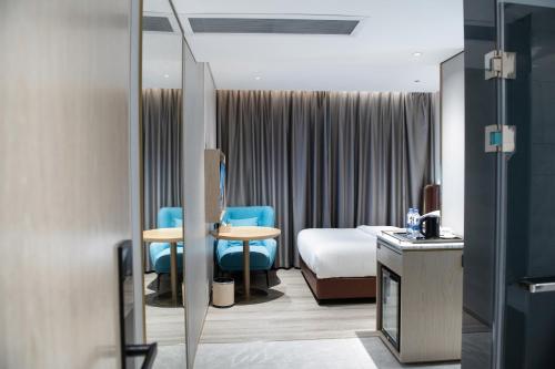 Habitación de hotel con cama y sillas azules en 上下九城市快捷酒店 en Cantón