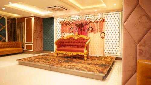 a living room with a red couch and a carpet at Hotel Park Regency in Gorakhpur