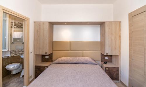 a bedroom with a large bed and a bathroom at Hotel Eura in Marina di Massa
