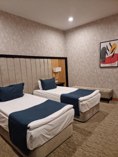a hotel room with two beds and a couch at Premium Hotel Ganja in Ganja