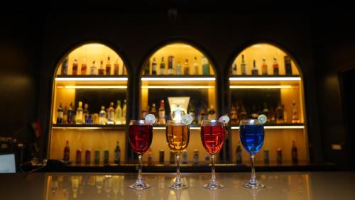 four wine glasses sitting on a table in front of a bar at Hotel Park Regency in Gorakhpur