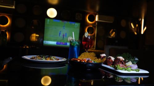 a table with two plates of food and a drink at Hotel Park Regency in Gorakhpur