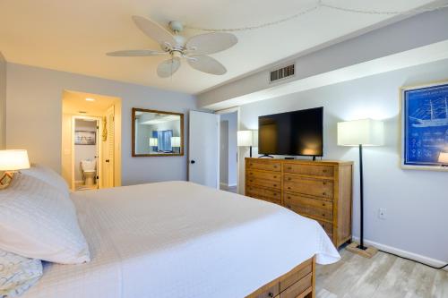 a bedroom with a white bed and a flat screen tv at Ocean Village Condo 3 Pools, Hot Tub and Beach in Fort Pierce