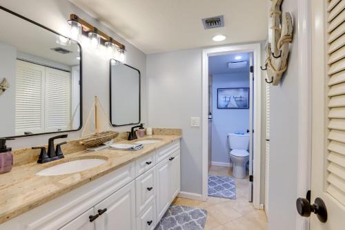 a bathroom with a sink and a mirror and a toilet at Ocean Village Condo 3 Pools, Hot Tub and Beach in Fort Pierce