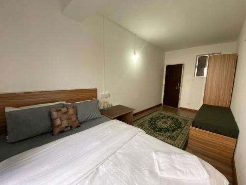 una camera con un grande letto bianco di Dorjay House. a Darjeeling