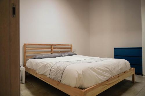 een slaapkamer met een houten bed met witte lakens bij Il Giardino dei Limoni - Leporano Marina (TA) in Leporano Marina