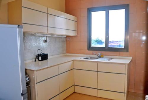 a small kitchen with a sink and a window at Résidence Sampo in Ouagadougou