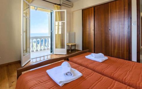 two beds in a bedroom with a view of the ocean at Bakers House in Gimari