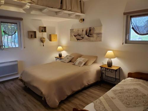 a bedroom with two beds and two lamps on tables at l'oustal dels amics in Saint-Pierre-de-Rivière