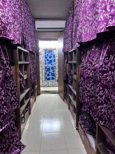 a hallway with purple curtains and a window at New Mahira Dormitory in Mumbai