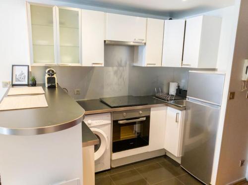 eine kleine Küche mit weißen Schränken und einem Geschirrspüler in der Unterkunft Appartement entier à louer in Villiers-sur-Marne