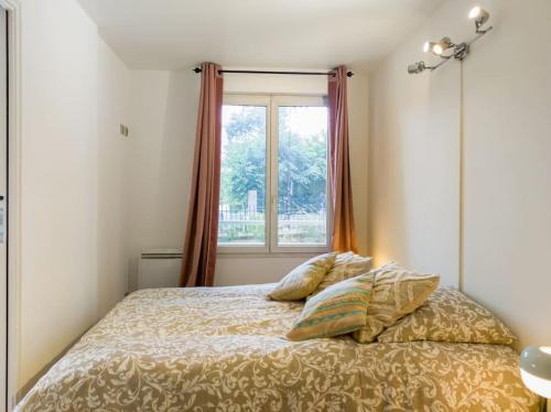 een bed met 2 kussens in een slaapkamer met een raam bij Appartement entier à louer in Villiers-sur-Marne