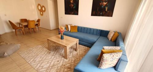 a living room with a blue couch and a table at Appartement gueliz de luxe in Marrakesh