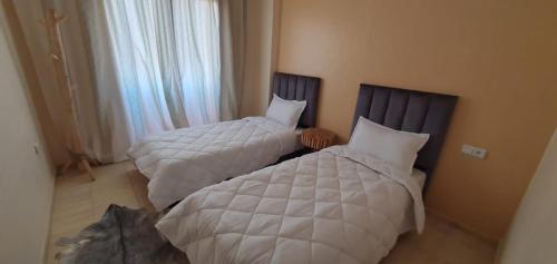 two beds sitting next to each other in a bedroom at Appartement gueliz de luxe in Marrakesh