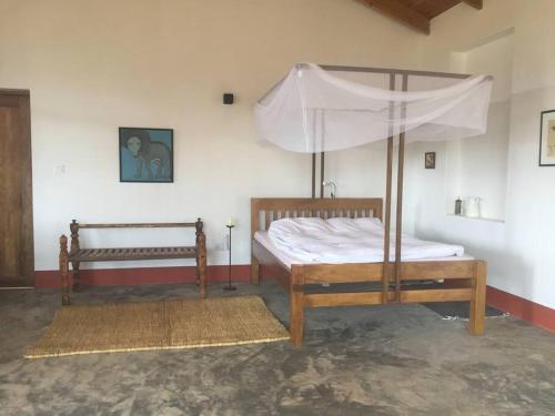 een slaapkamer met 2 bedden en een baldakijn bij Gongali House - Karatu Rewilded in Karatu