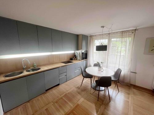 a kitchen with a table and a sink and a table and chairs at Comfy flat in city-FREE parking in Ljubljana