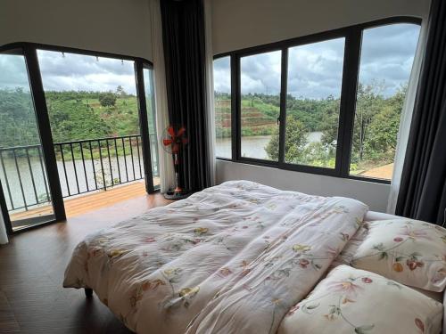 a bedroom with a bed with a view of a balcony at The FARM on the LAKE in Di Linh