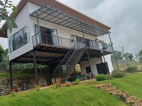 a house with a balcony and a staircase at The FARM on the LAKE in Di Linh