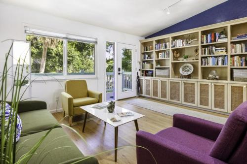 a living room with purple furniture and bookshelves at Dancing Dolphin home in Captiva