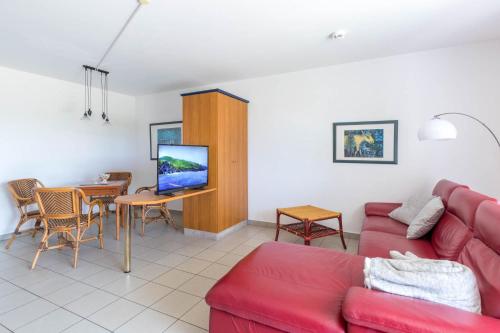 a living room with a red couch and a table at Haus Seeblick Wohnung 14 in Wohlenberg