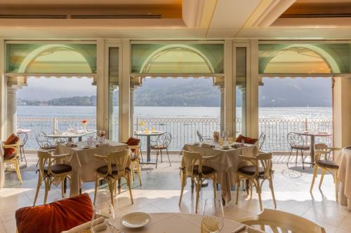 a restaurant with tables and chairs and a view of the water at La Darsena Boutique Hotel & Restaurant in Tremezzo
