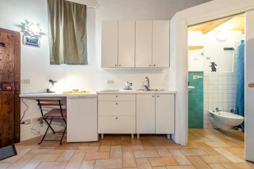 bagno con armadi bianchi, lavandino e vasca di Urbino Historical Central Studio! a Urbino