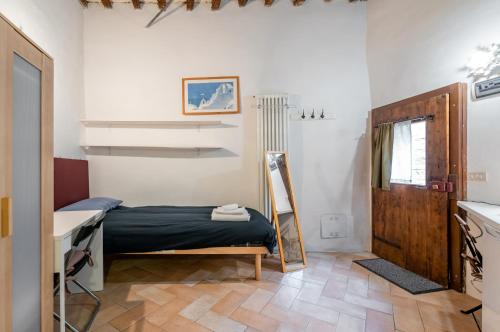 una camera con letto, scrivania e specchio di Urbino Historical Central Studio! a Urbino