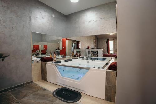 - une grande salle de bains pourvue d'une grande baignoire dans l'établissement Bordeaux City Center, à Novi Sad
