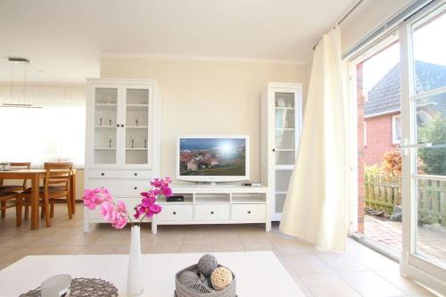 una sala de estar con TV en un armario blanco en Haus Jenny Wohnung H 4a, en Redewisch