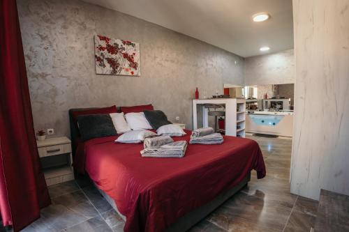 - une chambre avec un lit et une couverture rouge dans l'établissement Bordeaux City Center, à Novi Sad