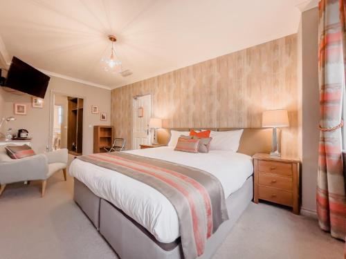 a bedroom with a large bed and a chair at The County in Newton Aycliffe