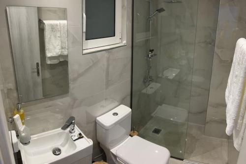a bathroom with a shower and a toilet and a sink at Ikarus Rhodes Center in Rhodes Town
