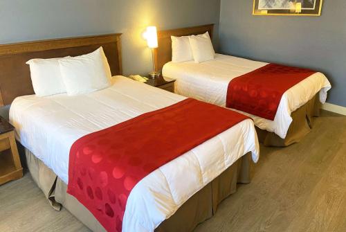 a hotel room with two beds with red and white sheets at Ramada by Wyndham Los Angeles/Wilshire Center in Los Angeles