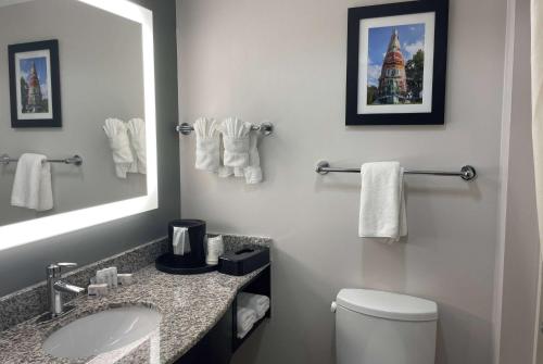 a bathroom with a sink and a toilet and a mirror at La Quinta Inn & Suites by Wyndham Tulsa Midtown in Tulsa