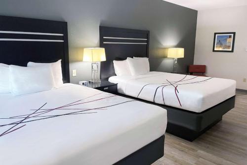 Habitación de hotel con 2 camas y 2 lámparas en La Quinta Inn & Suites by Wyndham Tulsa Midtown en Tulsa
