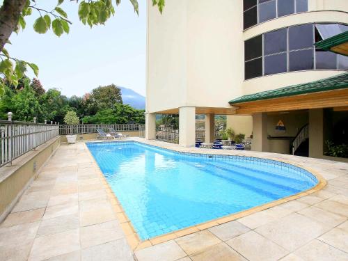 a swimming pool in front of a building at Mercure Jaragua do Sul in Jaraguá do Sul